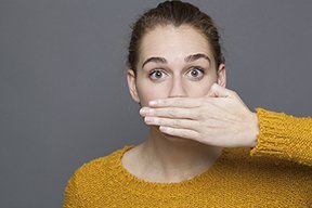 mujer tapandose la boca por tener mal aliento